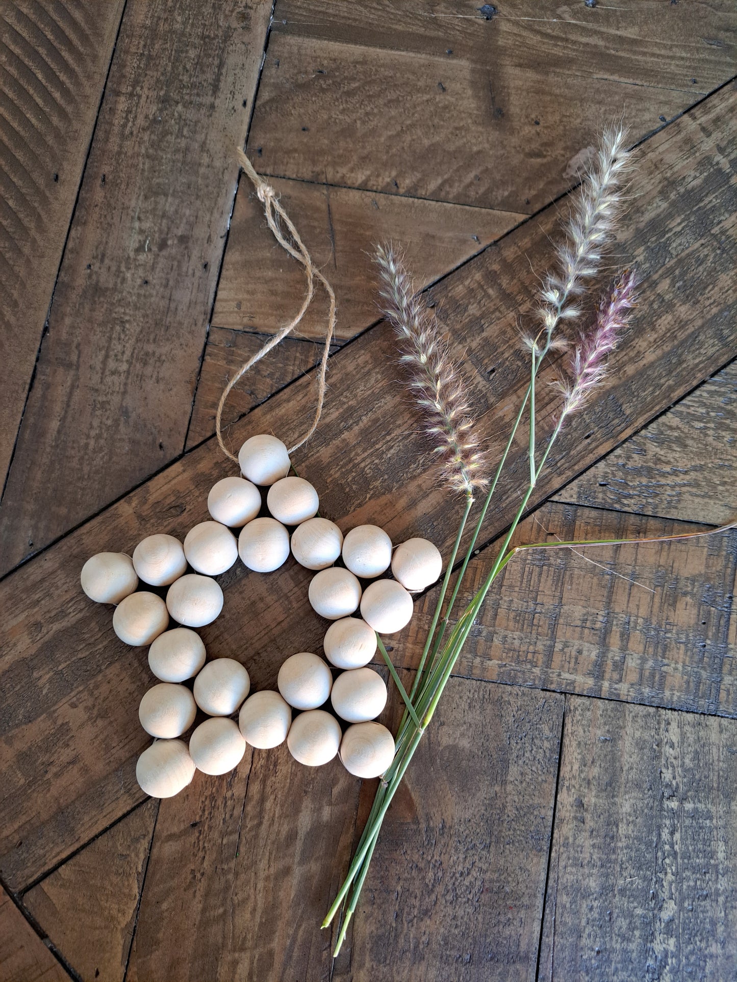 Weathered Landing's handmade wooden bead star. Beautiful in a nursery for a Scandi, boho, or modern farmhouse feel. Works great with neutral decor and is made with wood and jute. Find wooden bead stars at Weathered Landing. Located in Komoka, Ontario. Shipping to Canada and US.