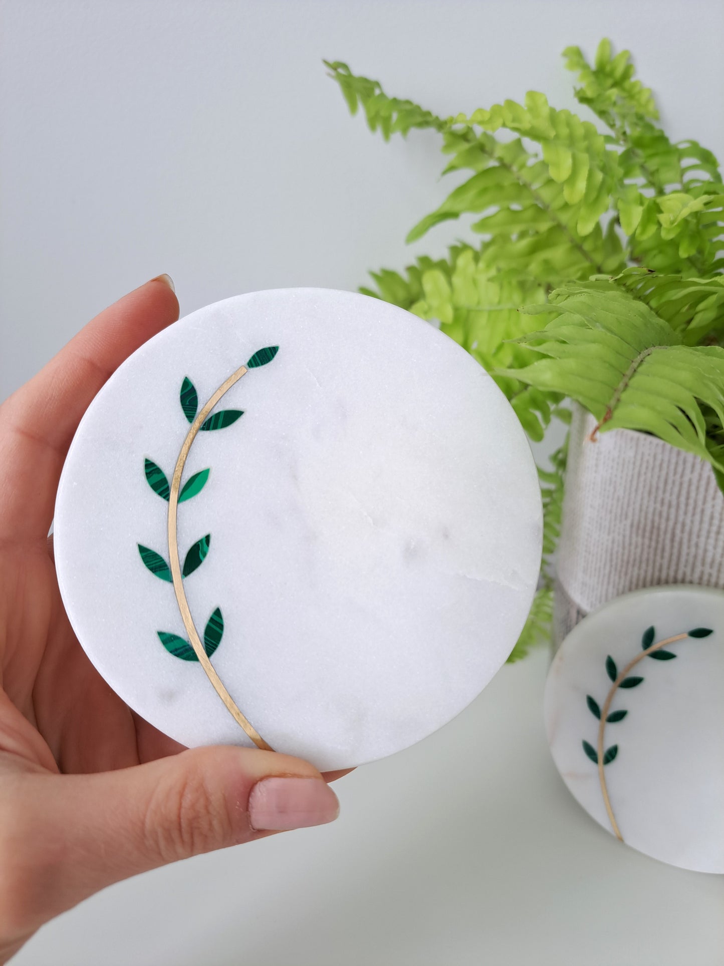 Hand-cut, artisan crafted olive branch coasters. Minimal yet stunning, these coasters made of white marble with brass inlay are sure to impress. Beautiful for a farmhouse, Mediterranean, or contemporary space.