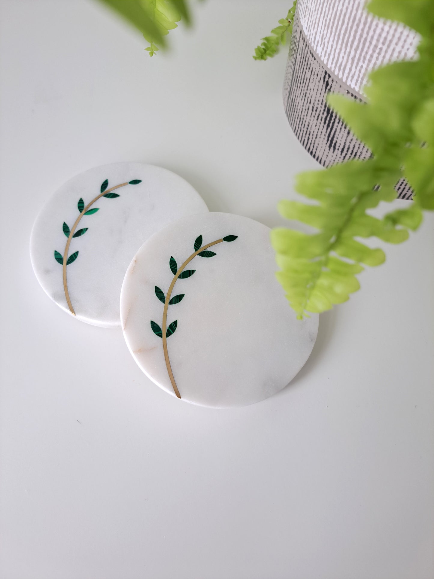 Hand-cut, artisan crafted olive branch coasters. Minimal yet stunning, these coasters made of white marble with brass inlay are sure to impress. Beautiful for a farmhouse, Mediterranean, or contemporary space.