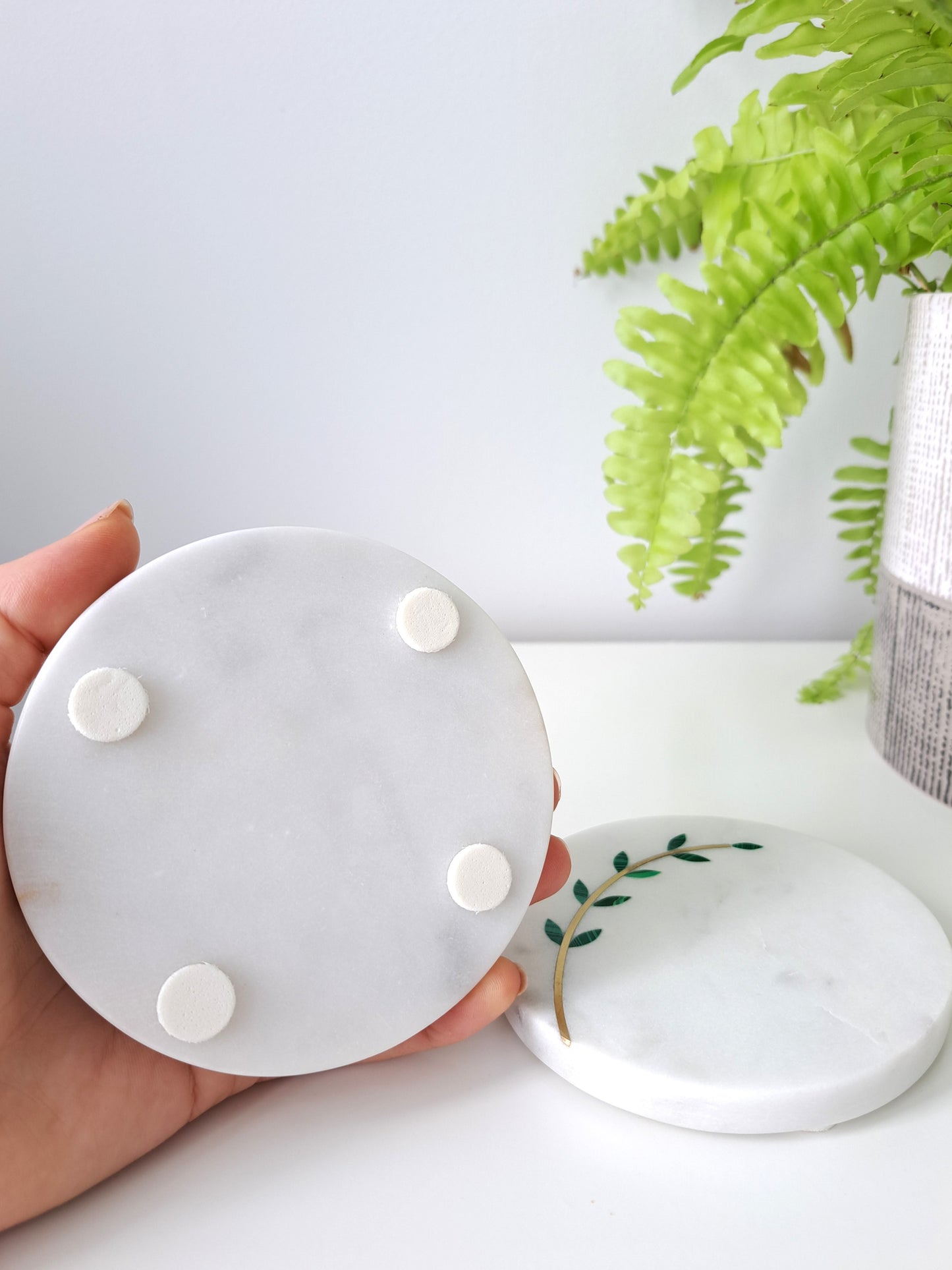 Hand-cut, artisan crafted olive branch coasters. Minimal yet stunning, these coasters made of white marble with brass inlay are sure to impress. Beautiful for a farmhouse, Mediterranean, or contemporary space.