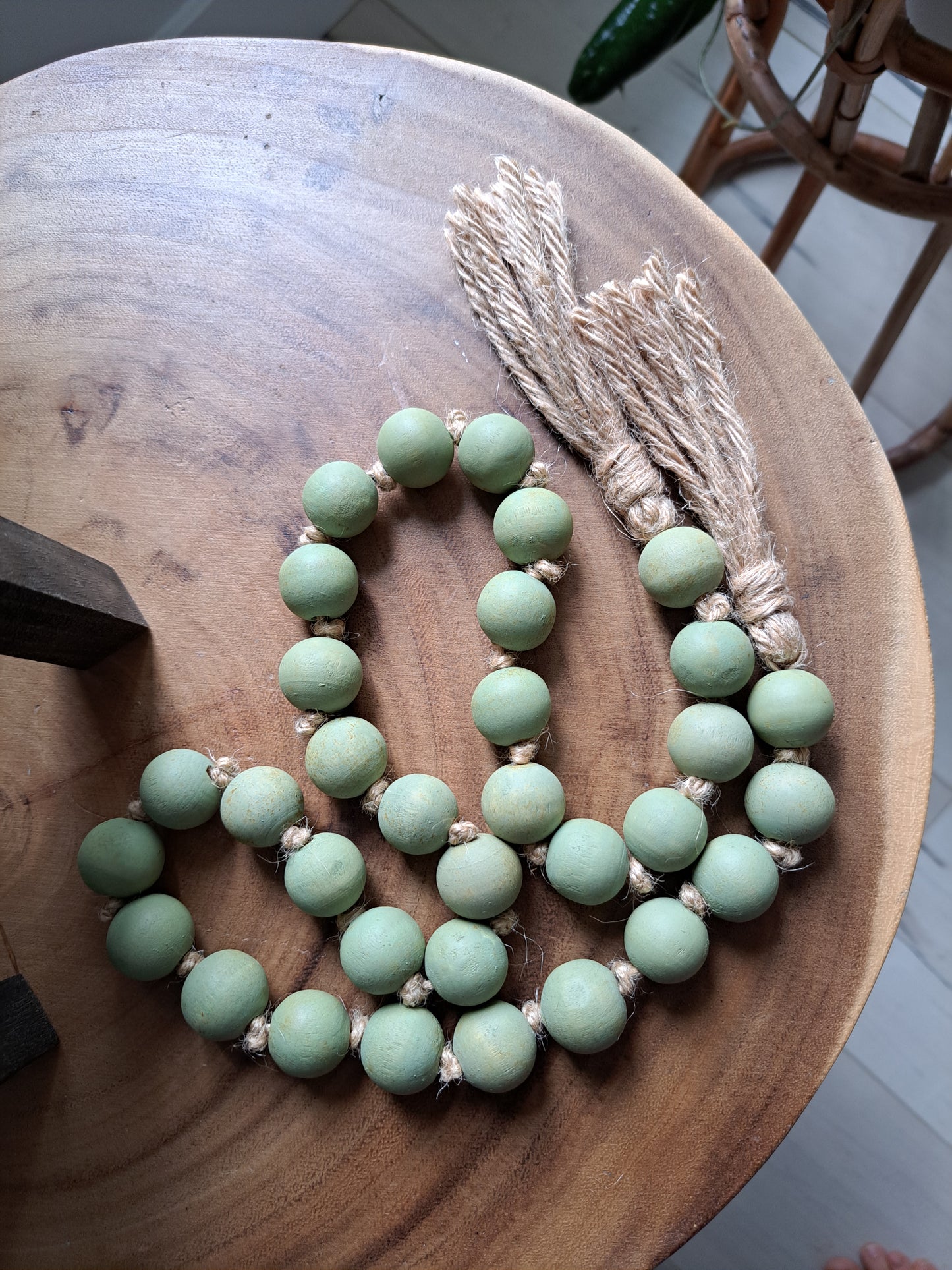 Weathered Landing's handmade sage green painted wooden bead garland with jute tassels. Made in Canada. Find garlands, plant hangers, pottery, art prints, and other home decor pieces at Weathered Landing. Located in Komoka with shipping to Canada and US.