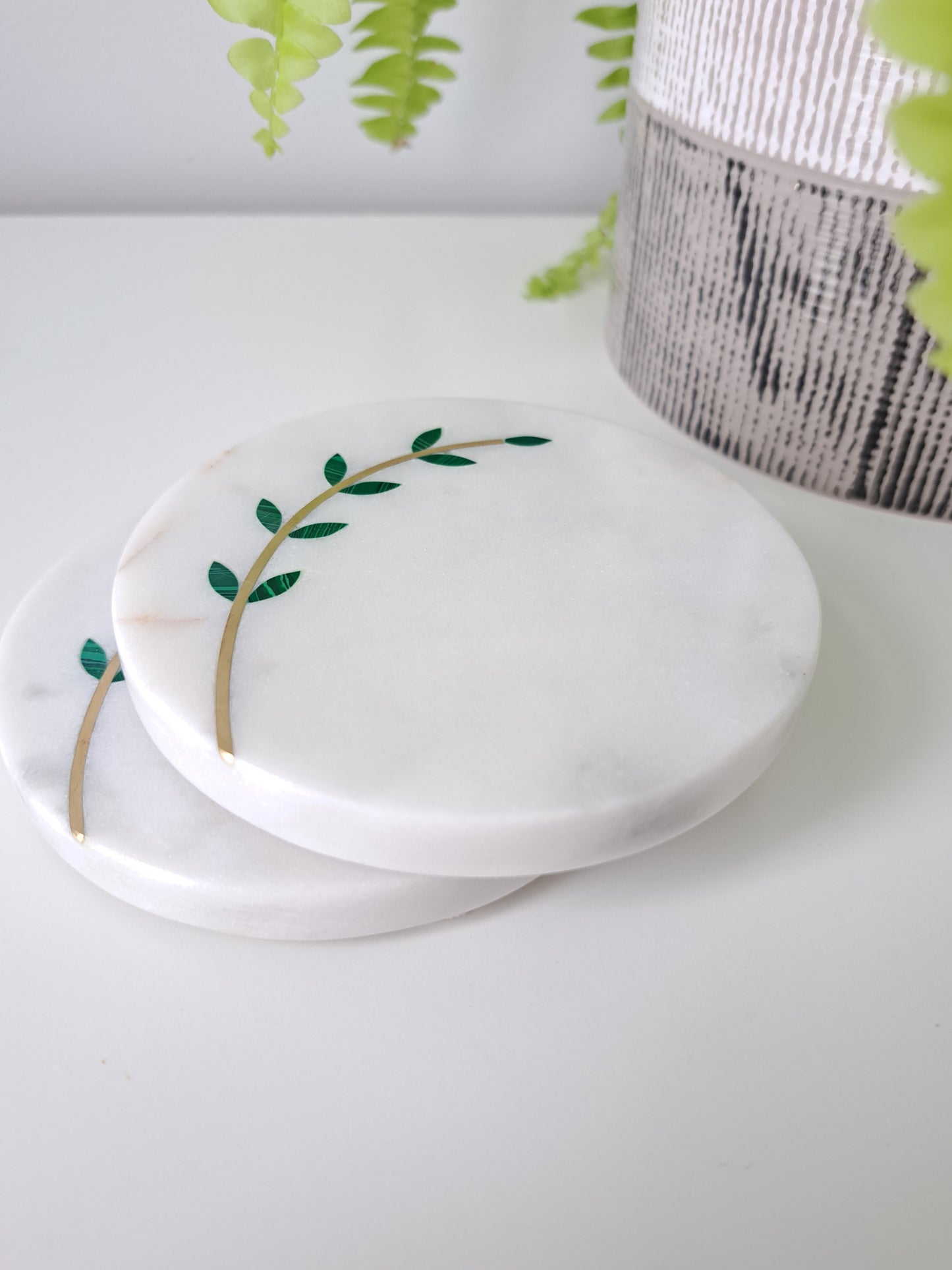 Hand-cut, artisan crafted olive branch coasters. Minimal yet stunning, these coasters made of white marble with brass inlay are sure to impress. Beautiful for a farmhouse, Mediterranean, or contemporary space.