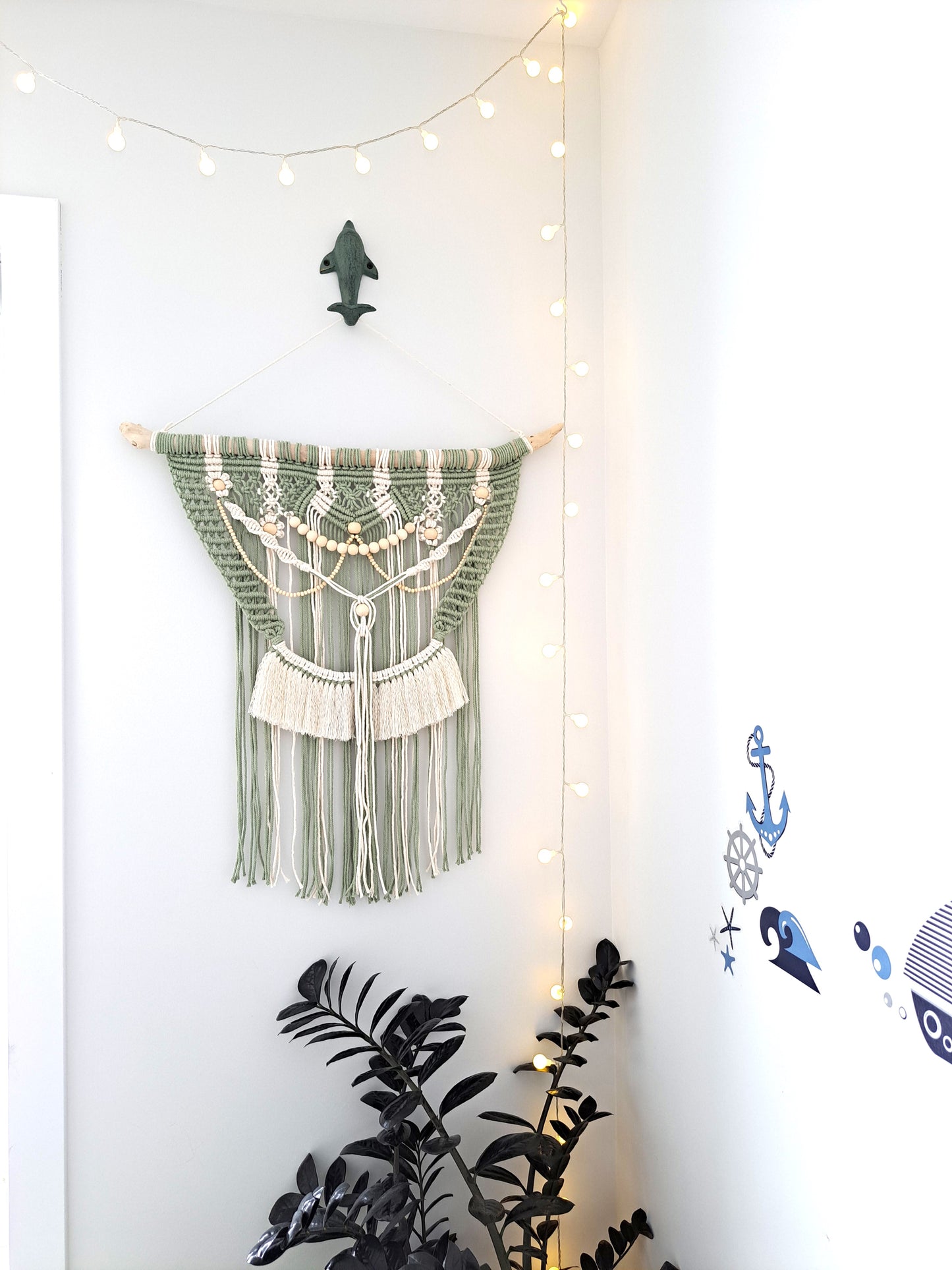 Weathered Landing's Boho Macrame Driftwood Wall Hanging. Handmade with sage green and white cotton macrame, wooden beads, and driftwood, this carefully crafted boho wall hanging is delicate and dainty. Perfect for a nursery or a bedroom nook. With lots of contrast in colour, texture, and pattern, this eclectic macrame wall hanging adds a bohemian feel to the space. Shipping to Canada and US.